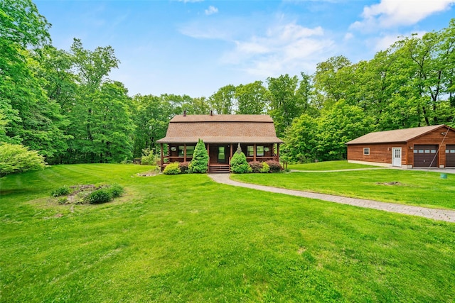 view of front of property with a porch, a detached garage, an outdoor structure, and a front yard