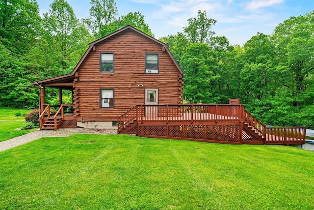 back of property featuring stairs, log siding, a yard, a deck, and a gambrel roof
