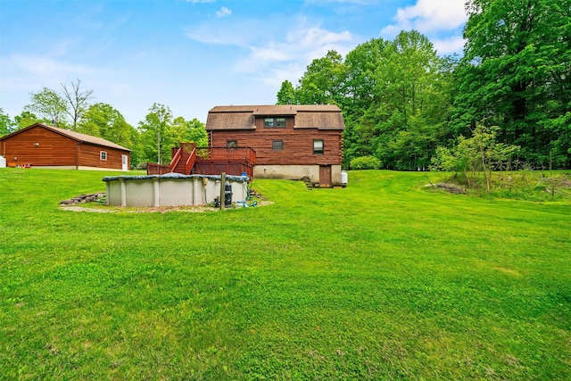 view of green lawn featuring a covered pool and a deck