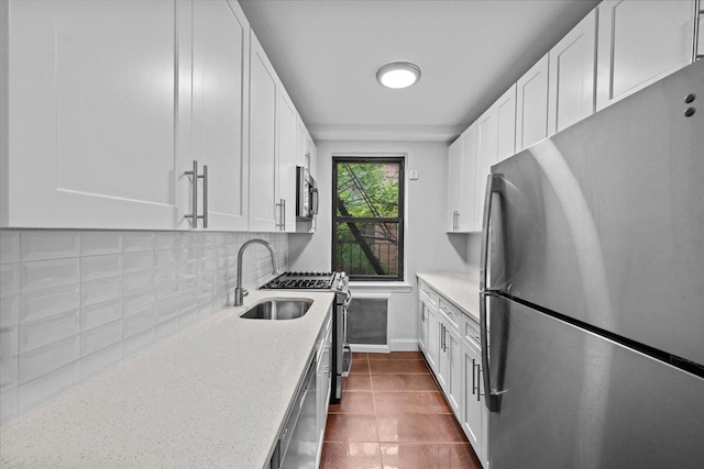 3840 Greystone Ave Unit 4K, Bronx, NY 10463 - kitchen with stainless steel appliances, a sink, baseboards, white cabinetry, and decorative backsplash