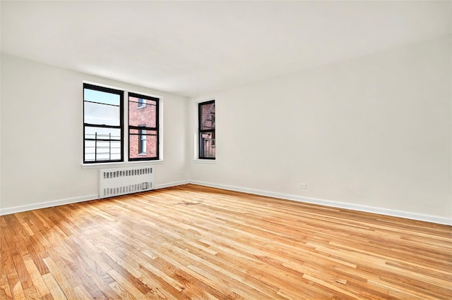 2244 Bronx Park E Unit 1E, Bronx, NY 10467 - empty room featuring radiator heating unit, light wood-style flooring, and baseboards