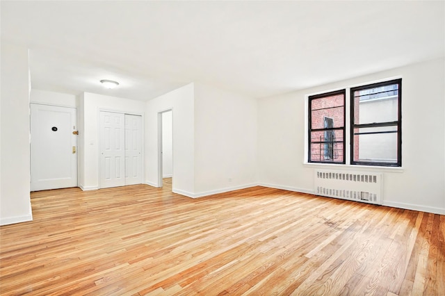 2244 Bronx Park E Unit 1E, Bronx, NY 10467 - spare room with radiator, light wood-style flooring, and baseboards