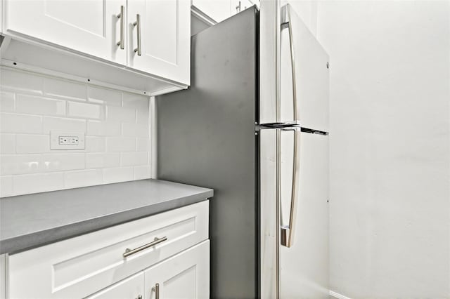2244 Bronx Park E Unit 1E, Bronx, NY 10467 - kitchen with backsplash, white cabinetry, dark countertops, and freestanding refrigerator