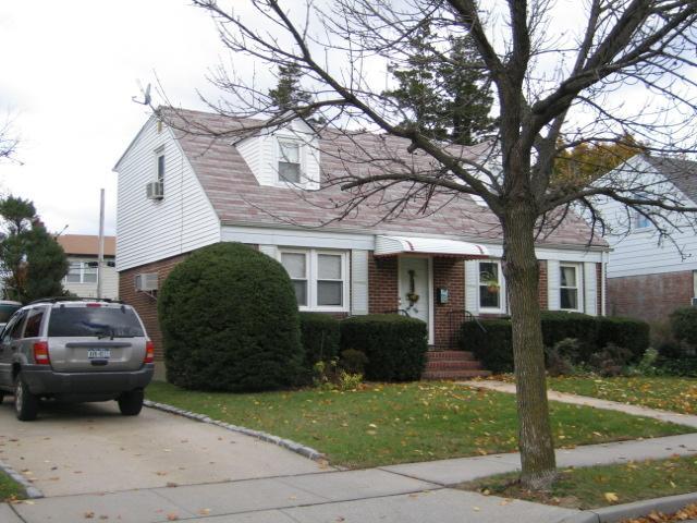 view of front facade featuring brick siding, a front lawn, and concrete driveway