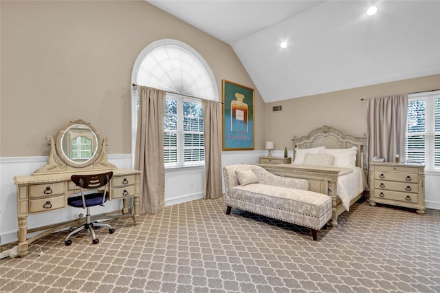 carpeted bedroom with lofted ceiling and an office area
