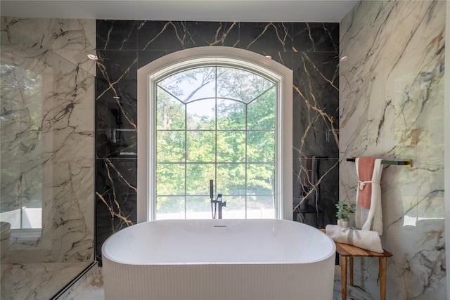 1259 Waterview Dr, Rockville Centre, NY 11570 - bathroom with stone wall, tile walls, a freestanding tub, and marble tiled floors
