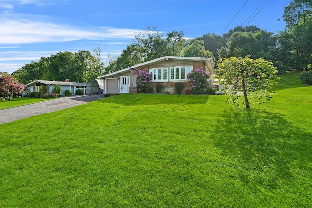 view of front facade with brick siding, driveway, a front lawn, and a garage