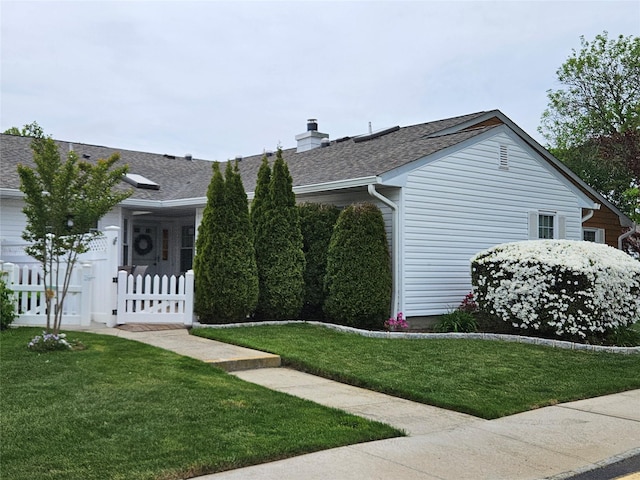 view of side of home featuring roof with shingles, a chimney, and a gate