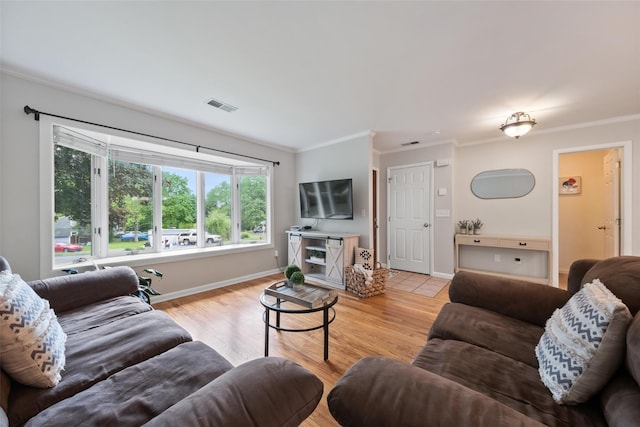living room featuring crown molding, light wood-style flooring, and baseboards