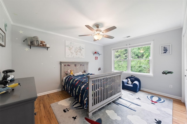 bedroom with crown molding, light wood-style flooring, baseboards, and ceiling fan