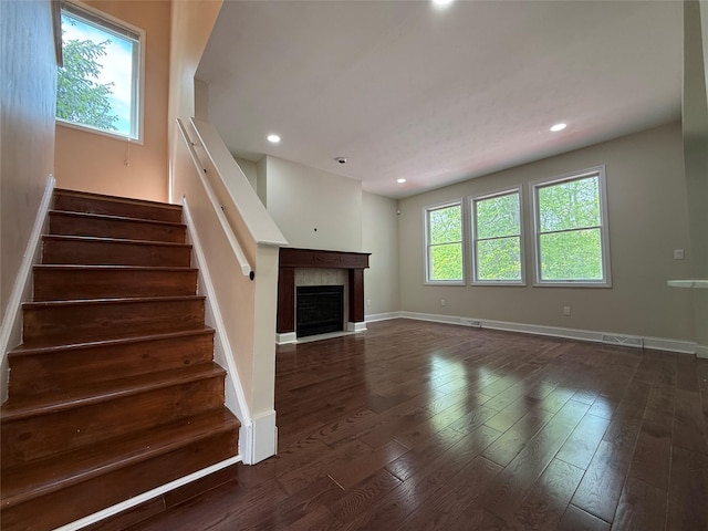 unfurnished living room with stairway, baseboards, wood finished floors, and recessed lighting