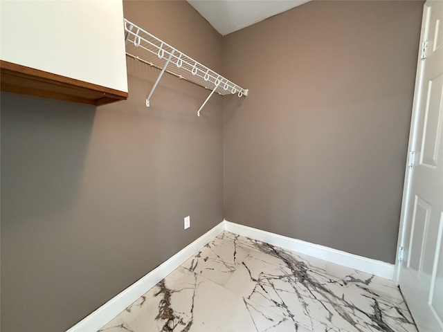 walk in closet with light marble finish floors