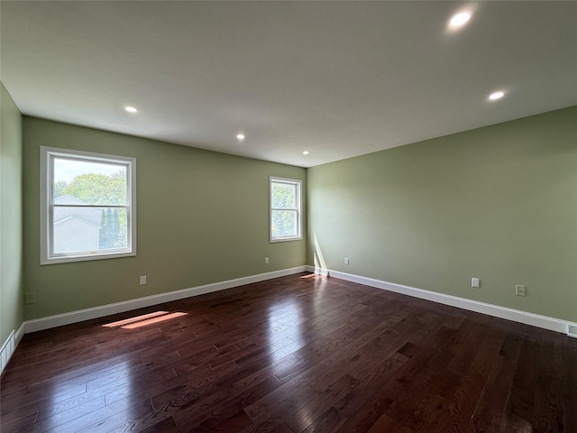 unfurnished room featuring dark wood-type flooring, recessed lighting, and baseboards