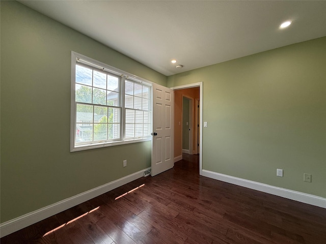 unfurnished bedroom featuring baseboards, dark wood finished floors, and recessed lighting
