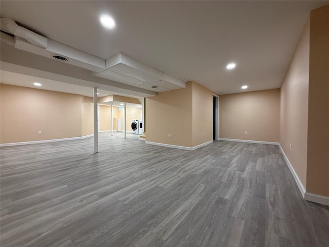 finished below grade area featuring wood finished floors, baseboards, and recessed lighting