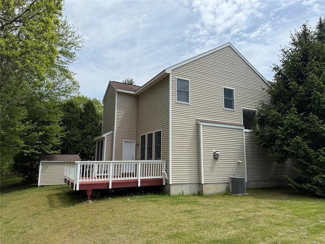 back of property with a deck, a yard, a storage shed, and central air condition unit