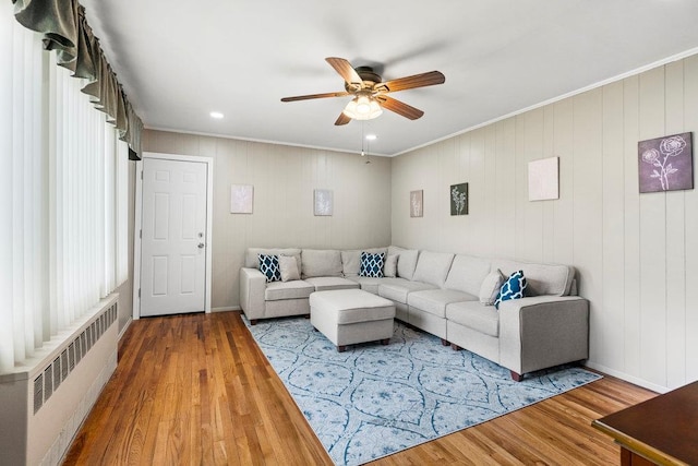 1544 Baldwin Blvd, Bay Shore, NY 11706 - living area featuring radiator heating unit, wood finished floors, a ceiling fan, and ornamental molding