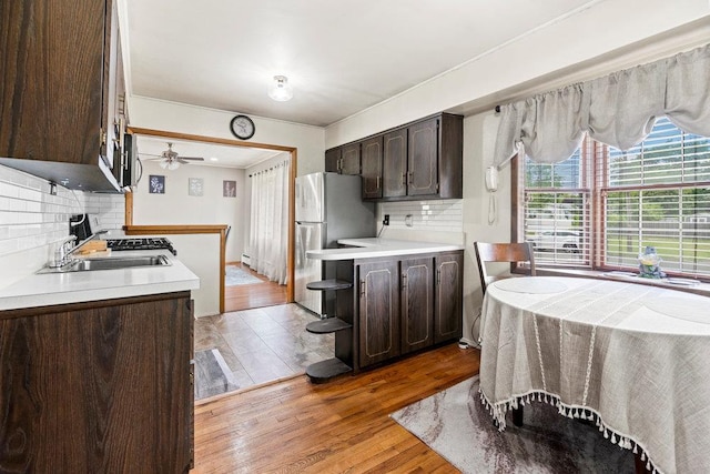 1544 Baldwin Blvd, Bay Shore, NY 11706 - kitchen featuring dark brown cabinets, freestanding refrigerator, decorative backsplash, and light countertops
