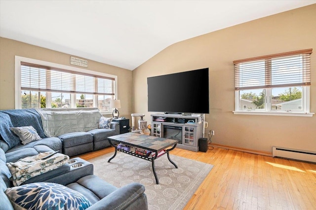 living area with vaulted ceiling, wood-type flooring, baseboard heating, and baseboards
