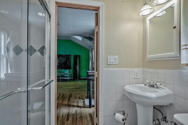 93 Broadway, Massapequa Park, NY 11762 - bathroom with tile walls, wood finished floors, toilet, wainscoting, and a shower with door