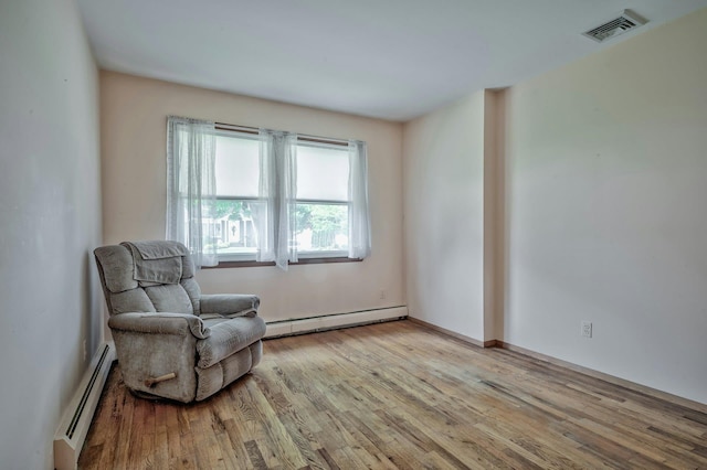 93 Broadway, Massapequa Park, NY 11762 - living area featuring baseboard heating and wood finished floors