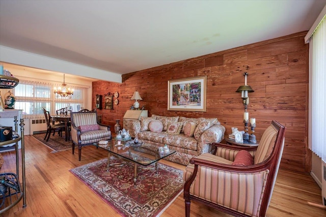 3176 Benjamin Rd, Oceanside, NY 11572 - living room with a chandelier, wood walls, wood finished floors, and radiator heating unit
