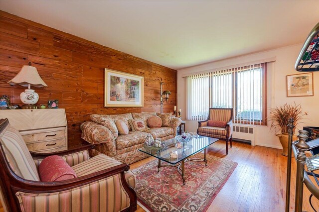 3176 Benjamin Rd, Oceanside, NY 11572 - living room featuring radiator, wooden walls, wood finished floors, and baseboards