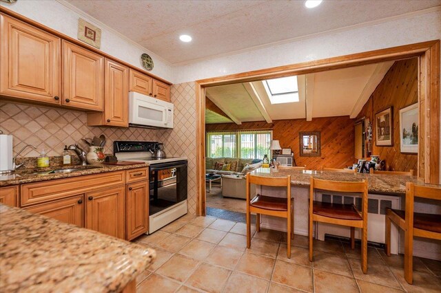 3176 Benjamin Rd, Oceanside, NY 11572 - kitchen with electric stove, white microwave, wood walls, crown molding, and tasteful backsplash