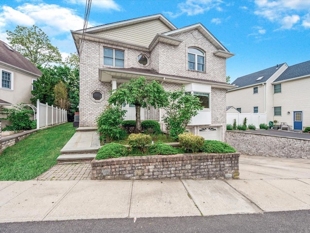 12 Pleasant Ave, Port Washington, NY 11050 - view of front facade with brick siding, fence, and a garage