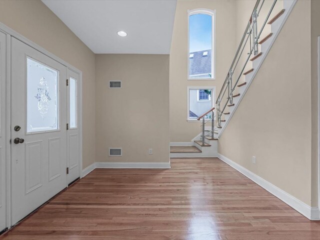 12 Pleasant Ave, Port Washington, NY 11050 - foyer entrance featuring healthy amount of natural light, stairs, baseboards, light wood-type flooring, and recessed lighting