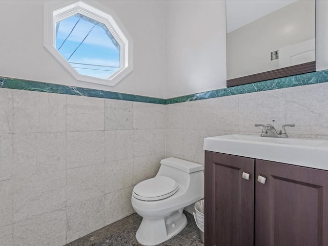 12 Pleasant Ave, Port Washington, NY 11050 - half bathroom featuring toilet, vanity, tile walls, and a wainscoted wall