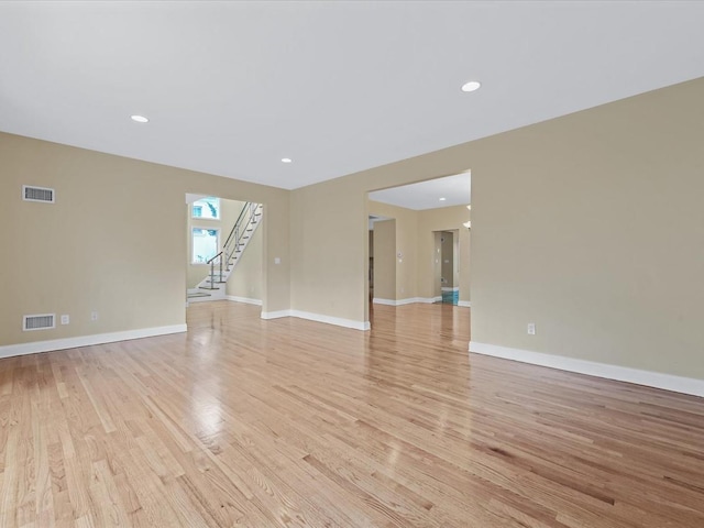 12 Pleasant Ave, Port Washington, NY 11050 - empty room with light wood finished floors, stairs, baseboards, and recessed lighting