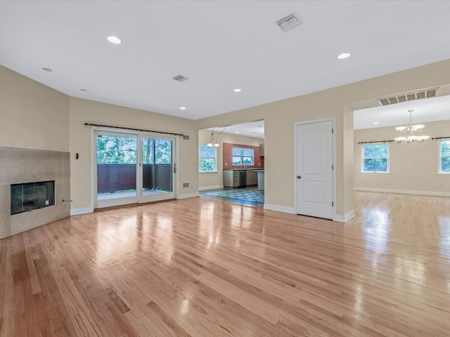 12 Pleasant Ave, Port Washington, NY 11050 - unfurnished living room with a chandelier, light wood-style floors, a high end fireplace, baseboards, and recessed lighting