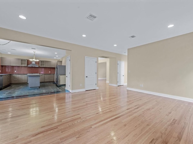 12 Pleasant Ave, Port Washington, NY 11050 - unfurnished living room with a chandelier, light wood finished floors, baseboards, and recessed lighting