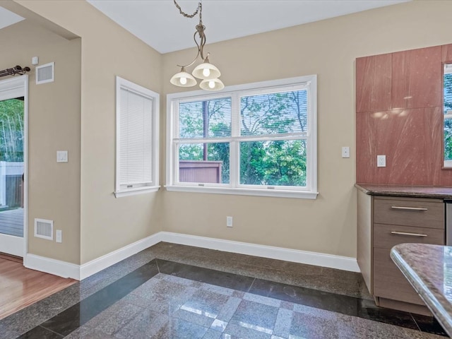 12 Pleasant Ave, Port Washington, NY 11050 - unfurnished dining area with granite floors, baseboards, and inlaid floor details