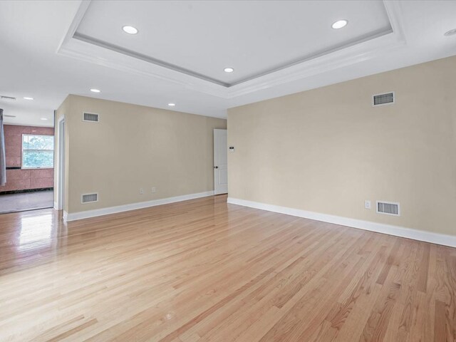 12 Pleasant Ave, Port Washington, NY 11050 - empty room featuring a tray ceiling, light wood-style flooring, recessed lighting, and baseboards