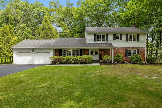11 Carnelli Ct, Poughkeepsie, NY 12603 - view of front of home with brick siding, driveway, a garage, a chimney, and a front yard