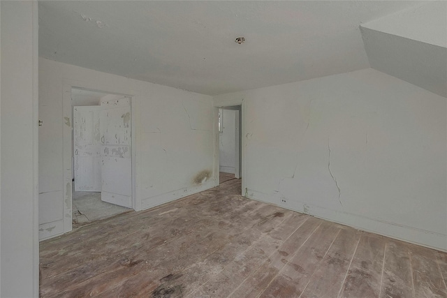 empty room with wood finished floors and lofted ceiling