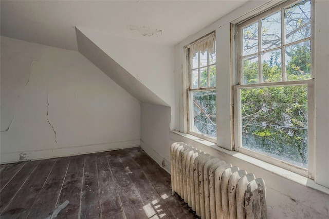 bonus room featuring radiator heating unit, hardwood / wood-style floors, lofted ceiling, and baseboards