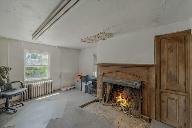 living room featuring radiator heating unit and a fireplace with flush hearth