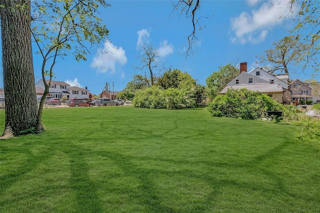 view of green lawn featuring a residential view