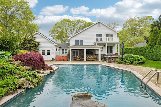 98 Beach Rd, Westhampton Beach, NY 11978 - rear view of property featuring a hot tub, a balcony, a patio area, and stone siding