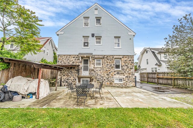 16 Rollhaus Pl, Port Chester, NY 10573 - back of property featuring stone siding, a fenced backyard, and a patio area