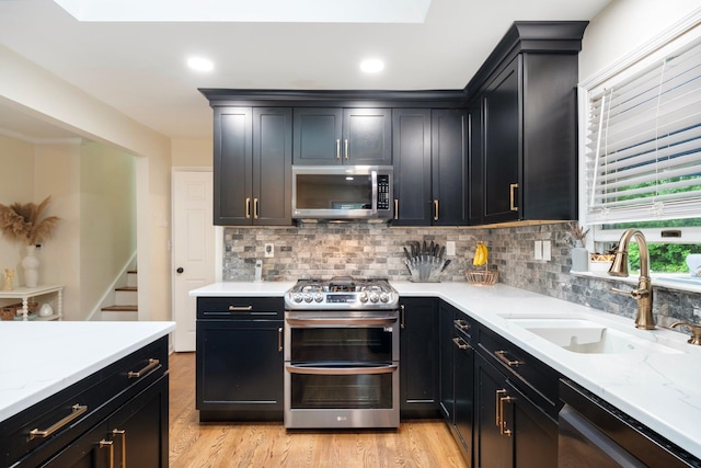 22 Willow Pl, Middletown, NY 10940 - kitchen featuring appliances with stainless steel finishes, a sink, light wood finished floors, dark cabinetry, and recessed lighting