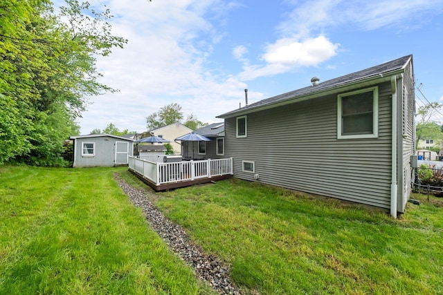 22 Willow Pl, Middletown, NY 10940 - rear view of house with a wooden deck, an outdoor structure, a storage unit, and a lawn