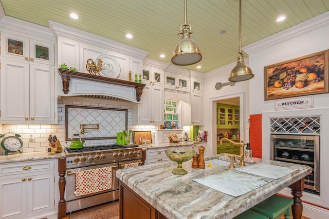 110 Red Spring Ln, Glen Cove, NY 11542 - kitchen with double oven range, a kitchen island, white cabinetry, ornamental molding, and wooden ceiling