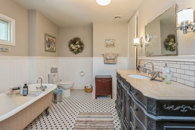 110 Red Spring Ln, Glen Cove, NY 11542 - bathroom with wainscoting, a soaking tub, vanity, toilet, and backsplash