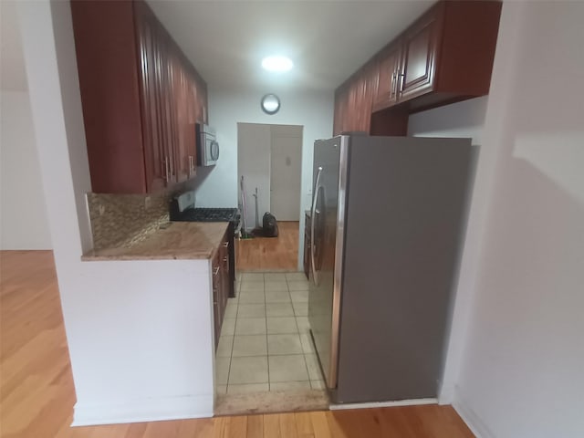 kitchen with stainless steel appliances and light tile patterned flooring
