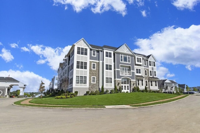 view of front of home featuring a front lawn and stone siding