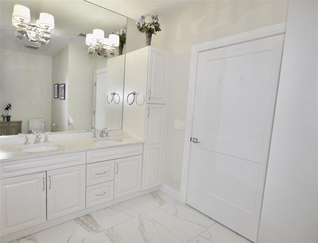 full bathroom with toilet, marble look tile flooring, a chandelier, and double vanity